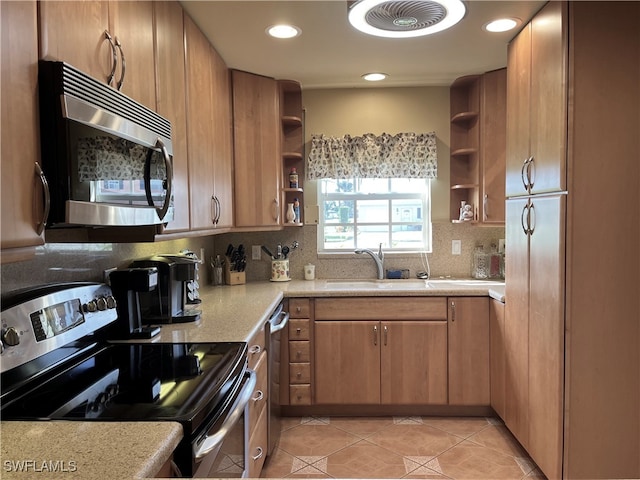 kitchen featuring tasteful backsplash, sink, light tile patterned floors, and stainless steel appliances