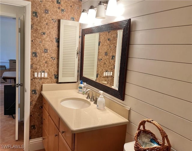 bathroom with tile patterned floors, vanity, and wood walls