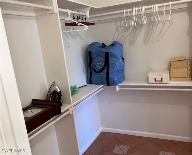 spacious closet with dark tile patterned floors