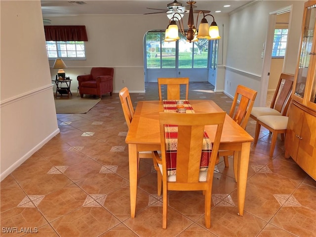 tiled dining area with ceiling fan with notable chandelier