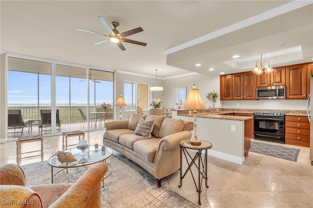 living room featuring a wall of windows, light tile patterned floors, ceiling fan, a tray ceiling, and crown molding