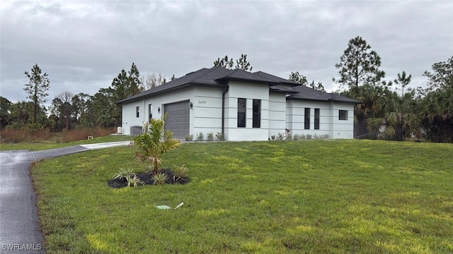 view of front of property with a garage and a front lawn