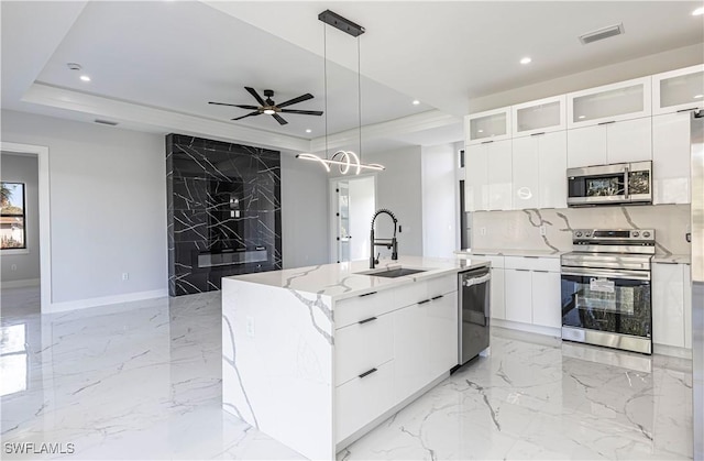 kitchen with recessed lighting, stainless steel appliances, a sink, marble finish floor, and modern cabinets