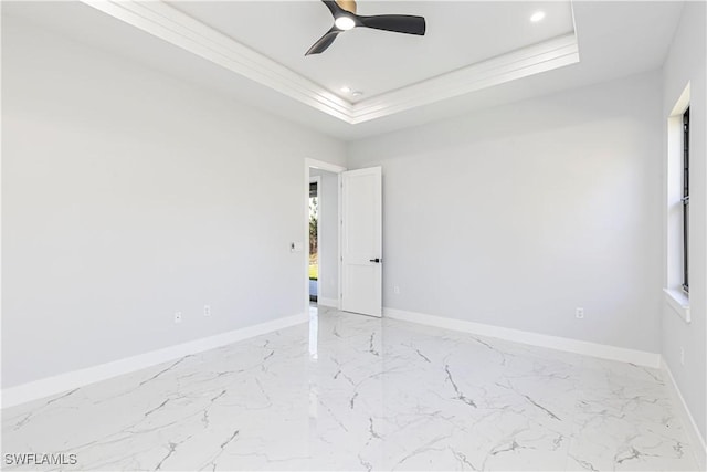 empty room featuring marble finish floor, baseboards, a tray ceiling, and recessed lighting