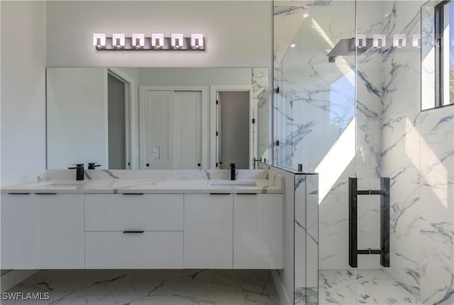 bathroom with double vanity, a marble finish shower, and a sink