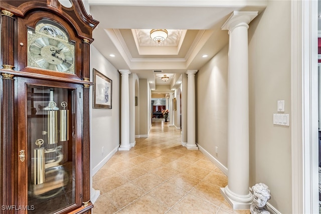 hallway featuring ornate columns, crown molding, a raised ceiling, and light tile patterned flooring