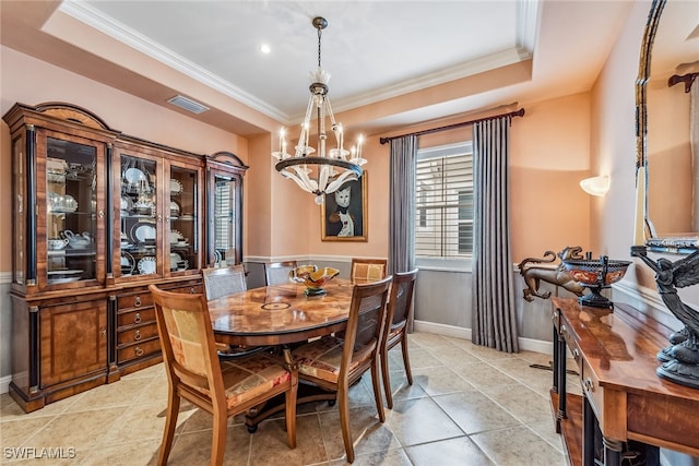 dining space featuring crown molding, a raised ceiling, and an inviting chandelier