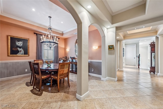 dining area with ornate columns, crown molding, a notable chandelier, and a tray ceiling