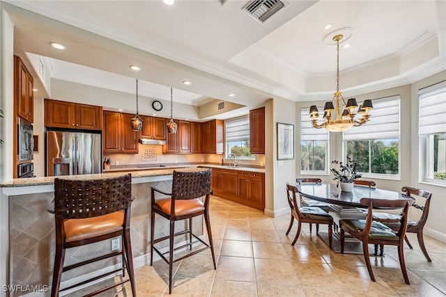 kitchen featuring sink, appliances with stainless steel finishes, light stone counters, and a raised ceiling