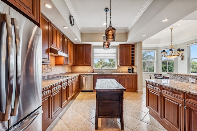 kitchen with a kitchen island, appliances with stainless steel finishes, light stone counters, and plenty of natural light