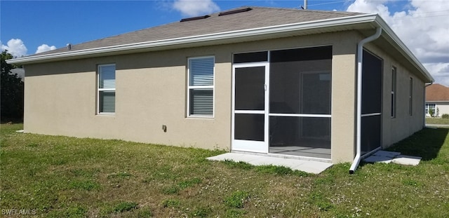 rear view of property featuring a sunroom and a yard