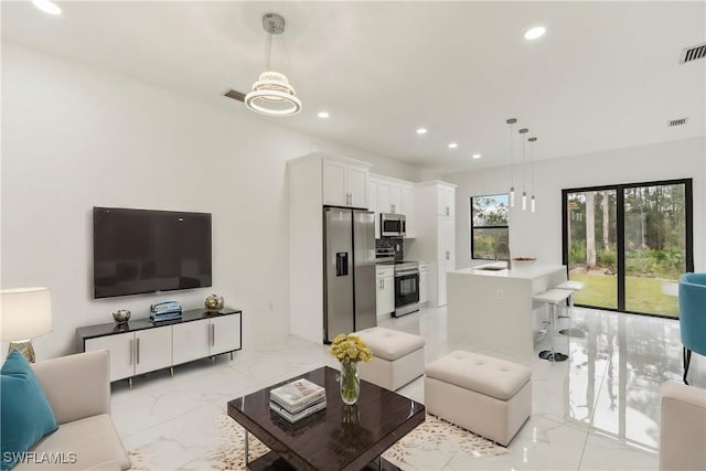 living room featuring an inviting chandelier and sink