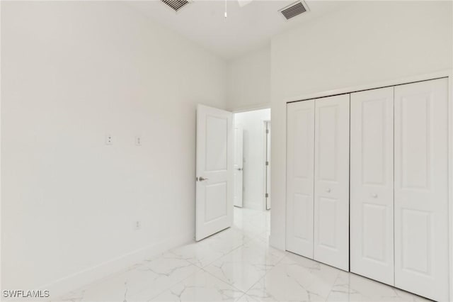 unfurnished bedroom with a closet and a high ceiling