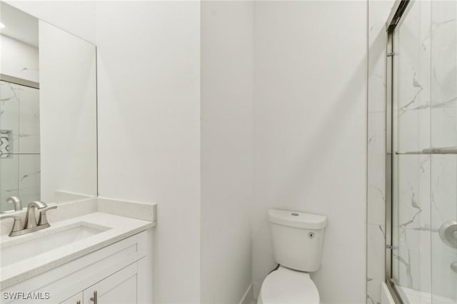 bathroom featuring vanity, toilet, and a shower with shower door