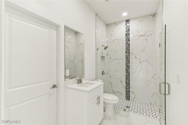 bathroom featuring vanity, a shower with shower door, and toilet