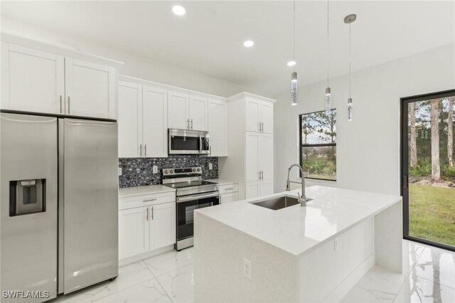 kitchen with pendant lighting, sink, white cabinets, and stainless steel appliances