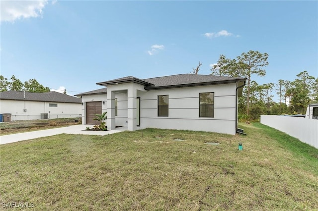 view of front of home with a garage, central air condition unit, and a front lawn