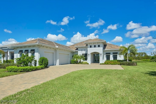 mediterranean / spanish-style home with a front yard and a garage