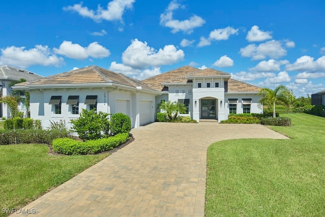 mediterranean / spanish house featuring a front yard and a garage