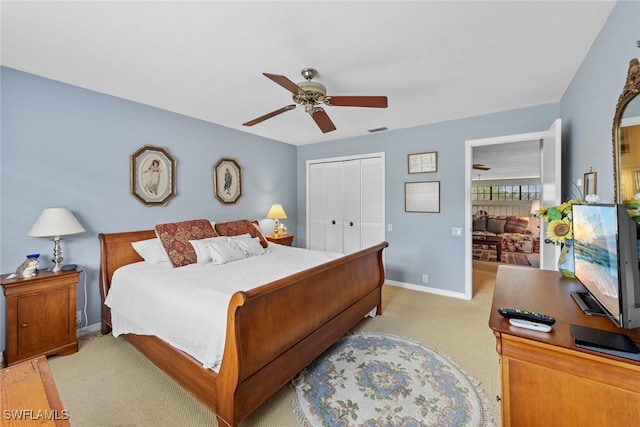 bedroom featuring light colored carpet, a closet, and ceiling fan