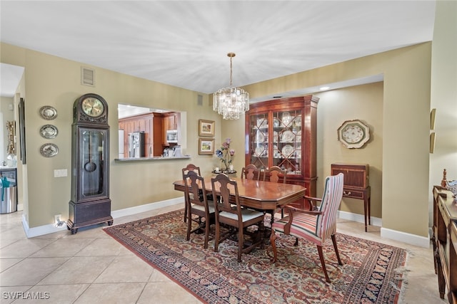 tiled dining area featuring a chandelier