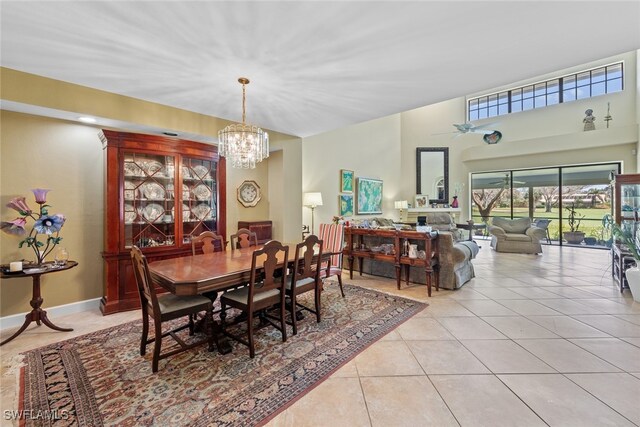 tiled dining room with ceiling fan with notable chandelier