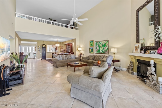 living room with ceiling fan with notable chandelier, high vaulted ceiling, and light tile patterned floors