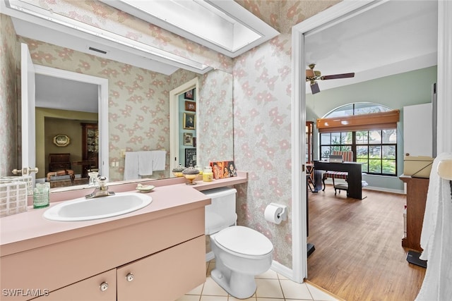 bathroom featuring vanity, toilet, wood-type flooring, and ceiling fan