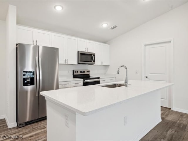 kitchen featuring dark wood-type flooring, white cabinets, stainless steel appliances, a kitchen island with sink, and sink