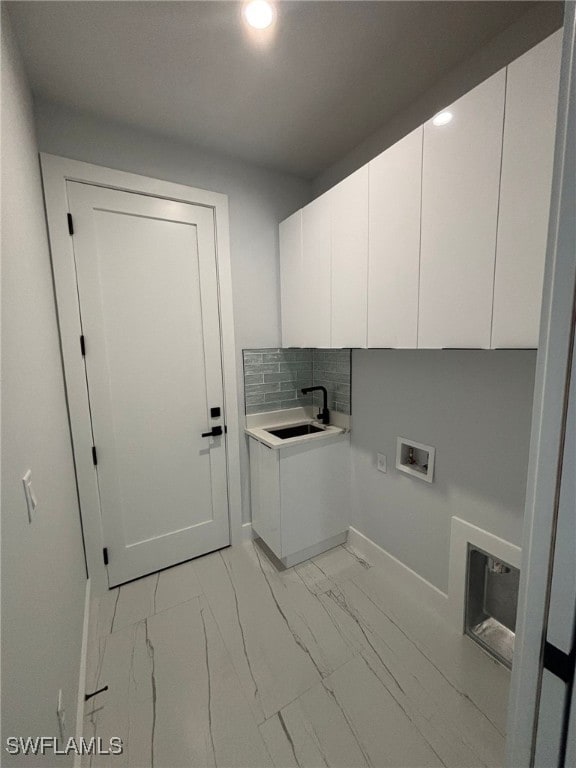 washroom with cabinets, hookup for a washing machine, and sink