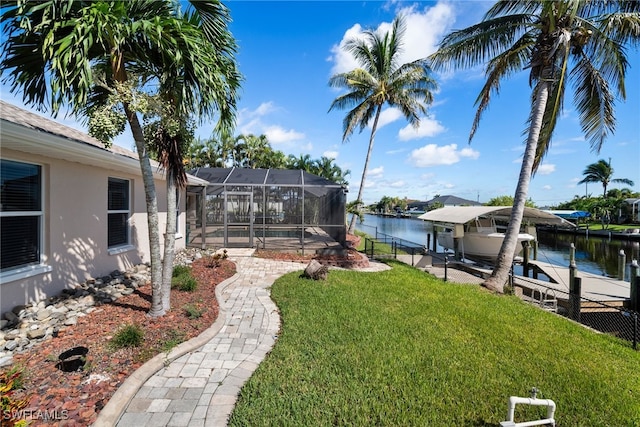 view of yard featuring a dock, a water view, and a lanai