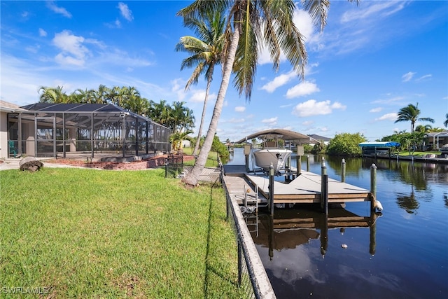 view of dock with a yard, a water view, and a lanai