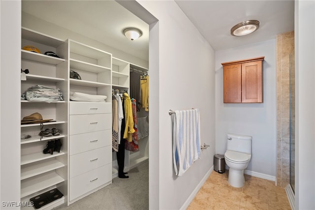 bathroom with tile patterned floors, a shower, and toilet