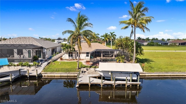 view of dock with a lanai, a lawn, and a water view