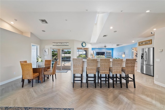 kitchen with a kitchen breakfast bar, stainless steel fridge with ice dispenser, and light parquet flooring