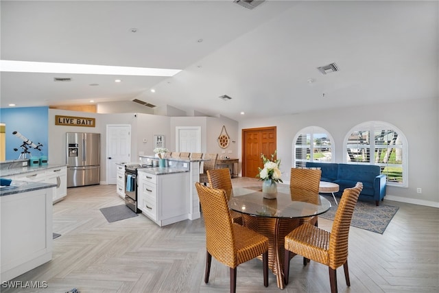 dining room featuring light parquet flooring and lofted ceiling