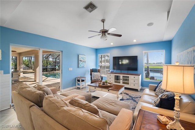 living room with ceiling fan and a wealth of natural light