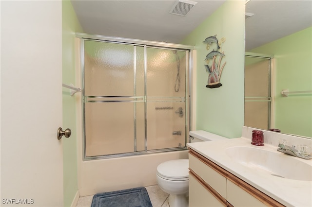 full bathroom featuring vanity, toilet, tile patterned floors, and bath / shower combo with glass door