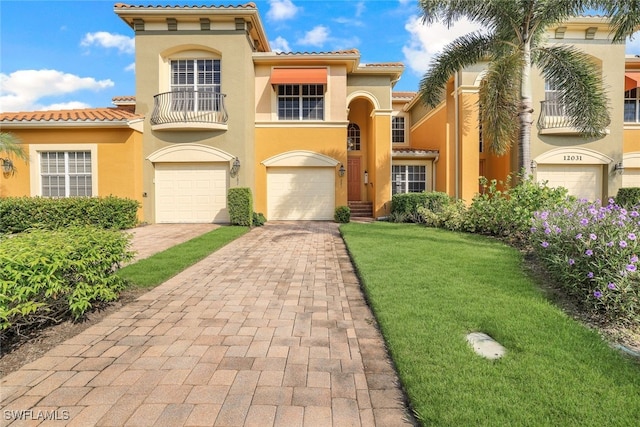 mediterranean / spanish house featuring a front yard, a garage, and a balcony