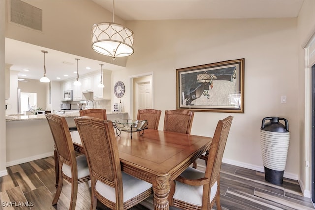 dining area featuring dark wood-type flooring and lofted ceiling