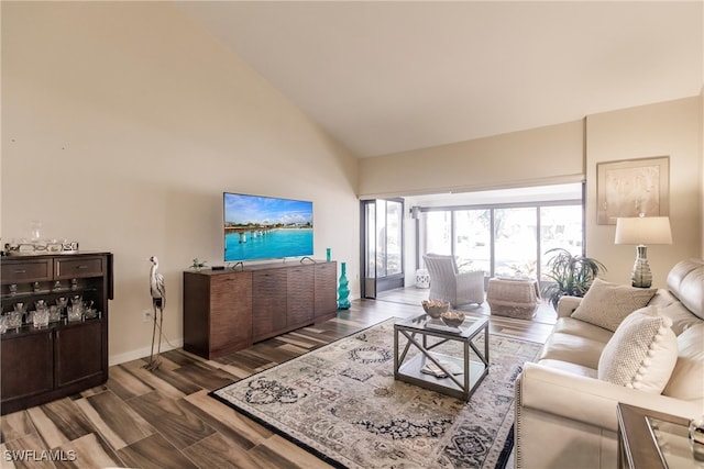 living room with dark hardwood / wood-style flooring and high vaulted ceiling