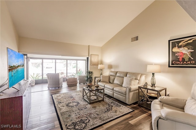 living room with high vaulted ceiling and dark wood-type flooring