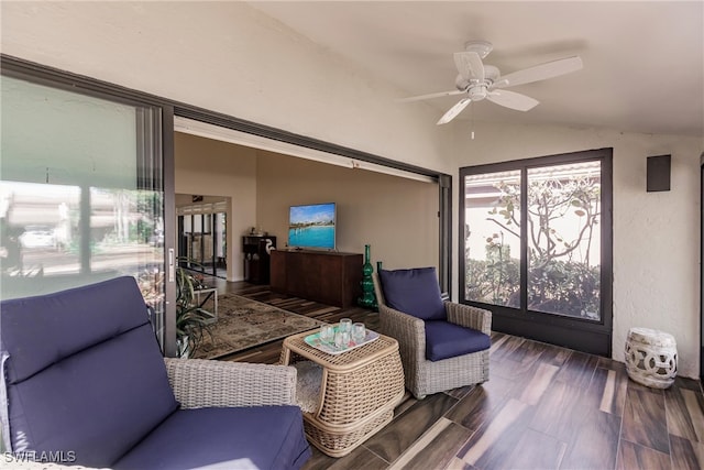 living room with ceiling fan, dark hardwood / wood-style flooring, and vaulted ceiling