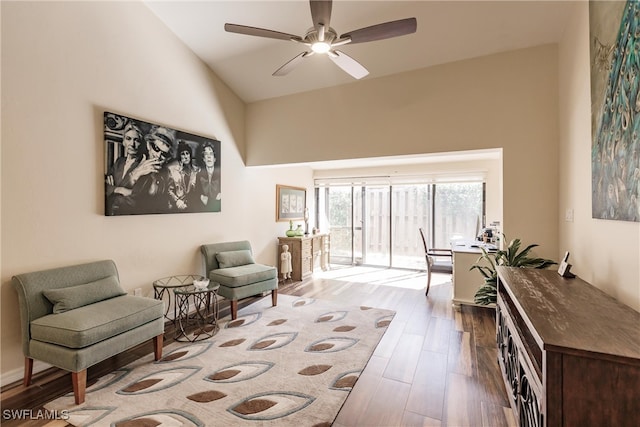 sitting room with wood-type flooring, high vaulted ceiling, and ceiling fan