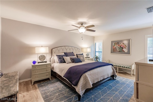 bedroom featuring multiple windows, ceiling fan, and dark wood-type flooring