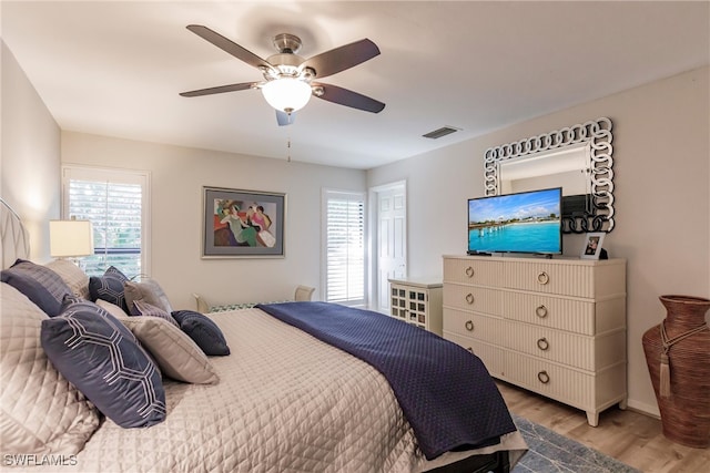 bedroom featuring multiple windows, ceiling fan, and hardwood / wood-style floors