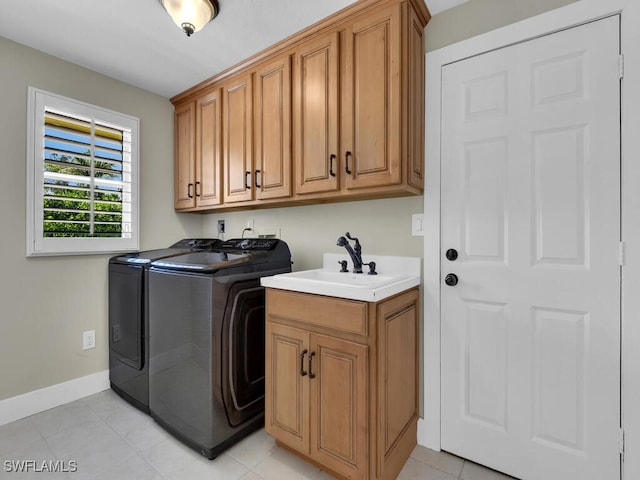 laundry area featuring cabinets, light tile patterned floors, washer and dryer, and sink