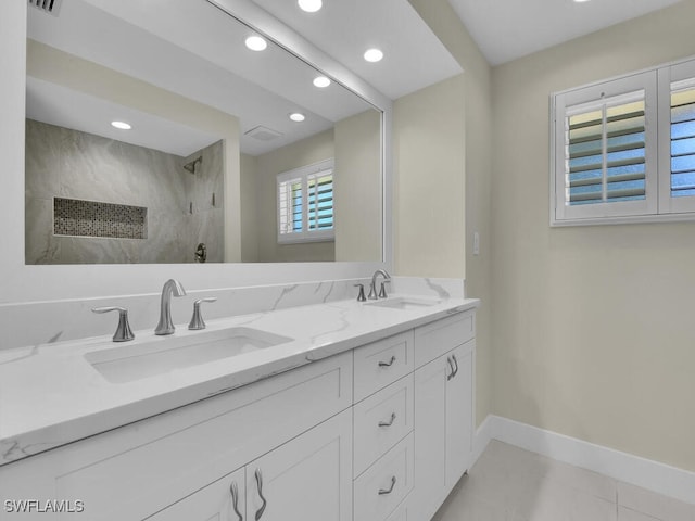 bathroom featuring tiled shower, vanity, and tile patterned flooring