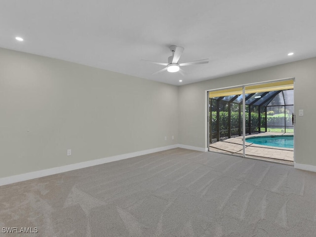 carpeted spare room featuring ceiling fan