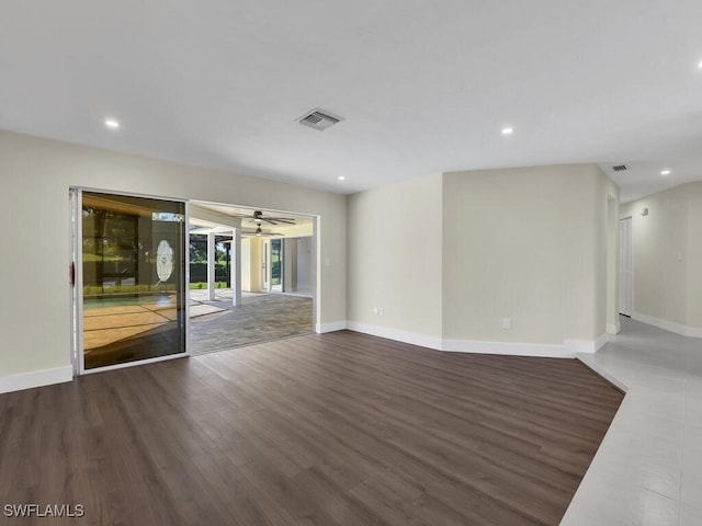 unfurnished living room with ceiling fan and dark wood-type flooring